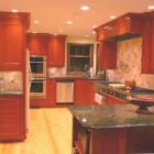 cherry cabinets - cherry cabinet kitchen with onyx backsplash - Lorie McMillan via Atticmag