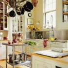stainless backsplash - White kitchen with stainless backsplash and work table and sink with prerinse faucet. - via Atticmag