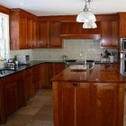 natural cherry cabinets in a kitchen with black granite counters - Atticmag