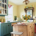 vintage look country cottage kitchen with yellow walls, a pine island and teal cabinets.- via Atticmag