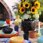 glazed pottery - outdoor dining table set with colorful Bauer pottery dishes via Atticmag