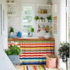 colorful cottage style stripes on a sink skirt and rug in a white cottage kitchen - magnusselander via atticmag