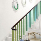 colorful painted staircase - white staircase with multicolor green spindles - terrys fabrics via atticmag