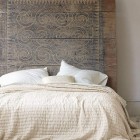 wall mounted headboards - wood plank headboard with Vitruvian scoll incising – Eileen Fisher via Atticmag