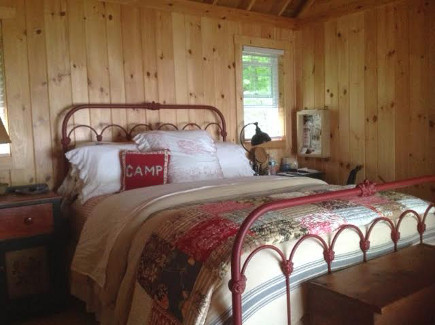 pine-paneled master bedroom of the Maine Lake Camp house - Atticmag