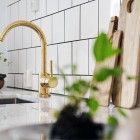 brass accent - modern white and gray kitchen with brass faucet and hardware - KuchniAremont via Atticmag