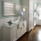 laundry room sink - Kohler Gilford vitreous china, 30-inch sink set in a custom cabinet in a coastal style laundry room - Rabaut Design via Atticmag